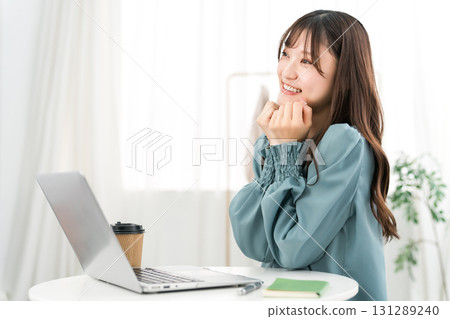 Young Asian businesswoman happy looking at computer at office/workplace 131289240