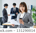Smiling woman with coffee in her hand in the office 131290014