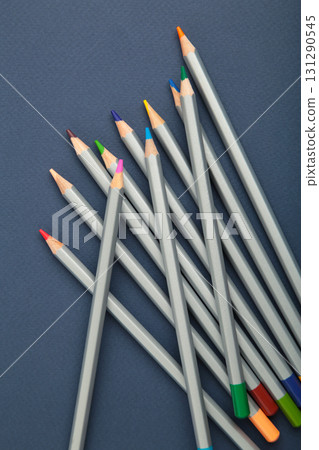 Many colorful pencils on dark blue background. Vertical photo 131290545