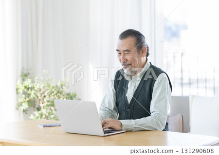 一位 70 多歲的男子正在使用筆記型電腦 131290608