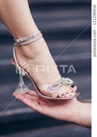 A man is holding a woman's foot in his hand 131290656