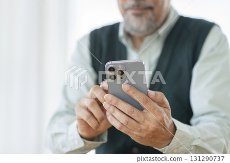 Hands of a senior man operating a smartphone 131290737