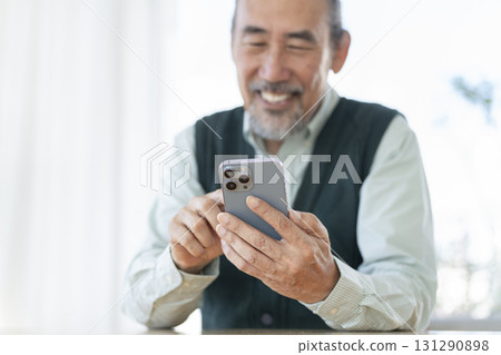 一位微笑的老人用智慧型手機的手 131290898