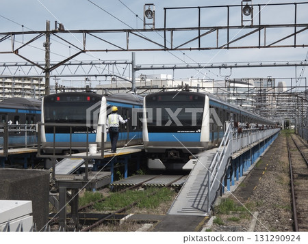 Workers inspecting the E233 series train at the depot Workers inspecting the E233 series train at the depot 131290924