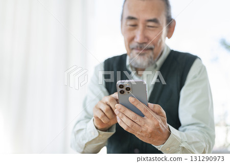 一位 70 多歲男士正在操作智慧型手機的手 一位 70 多歲男士正在操作智慧型手機的手 131290973
