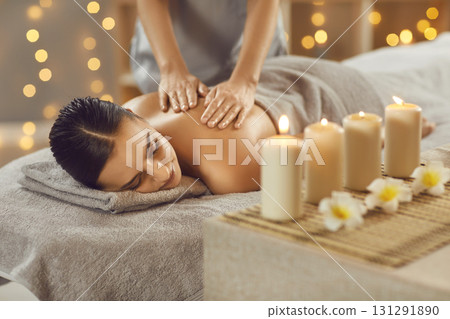 Young woman relaxing in spa salon with hot stones along spine 131291890