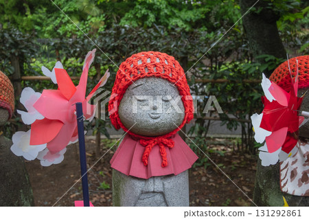 Stone Jizo statue wearing red knitted hat and bib in Japanese garden at Tokyo, Japan Stone Jizo statue wearing red knitted hat and bib in Japanese garden at Tokyo, Japan 131292861