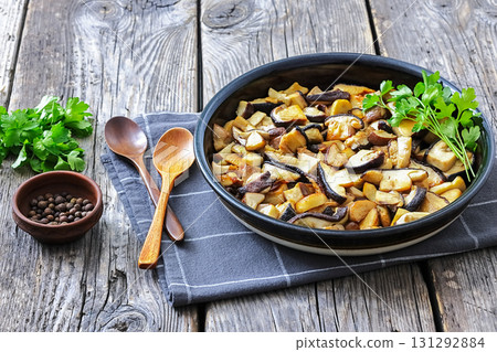 fried wild porcini mushrooms, ceps in a black bowl 131292884