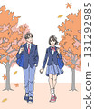 Men and women in uniforms walking along a tree-lined road in autumn, vertical 131292985