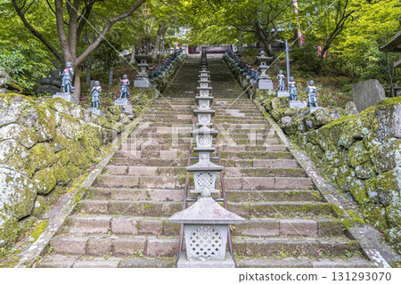 Stone lanterns lining mossy steps in a serene Japanese temple garden at Oyama mountain, Isehara, Kanagawa, Japan 131293070