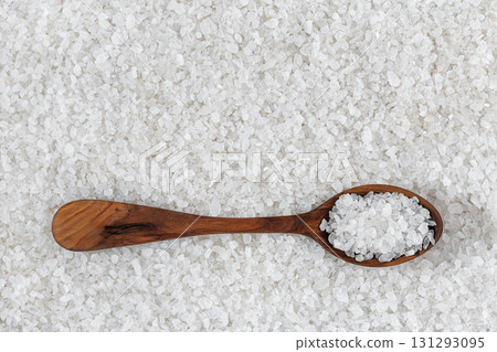 Sea salt crystals in wooden spoon with forming textured background, representing healthy cooking Sea salt crystals in wooden spoon with forming textured background, representing healthy cooking 131293095