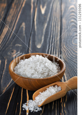 White sea salt in bowl and scoop on dark wooden table White sea salt in bowl and scoop on dark wooden table 131293096