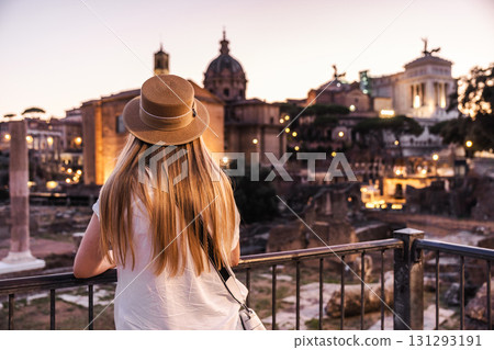 Young woman looking at Roman Forum ruins and historical buildings at dusk in Rome, Italy 131293191