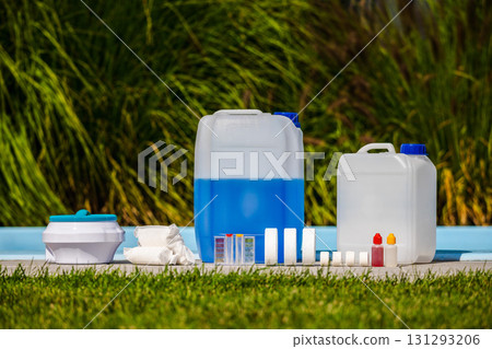 Pool maintenance products set with chemical canisters, chlorine tablets, test kit and cleaning supplies arranged near swimming pool outdoors Pool maintenance products set with chemical canisters, chlorine tablets, test kit and cleaning supplies arranged near swimming pool outdoors 131293206