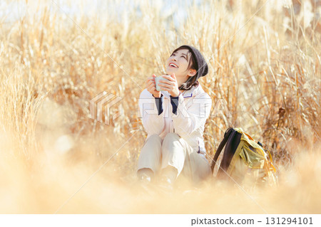 Woman drinking coffee in nature Woman drinking coffee in nature 131294101