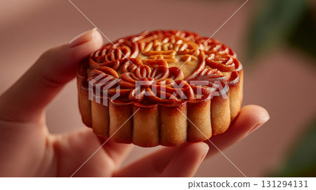 Hand of woman holding a mooncake. Chinese Mid-Autumn Festival concept Hand of woman holding a mooncake. Chinese Mid-Autumn Festival concept 131294131