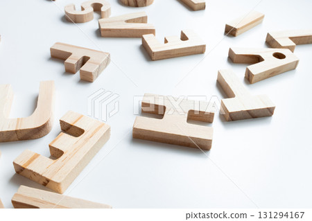 Wooden alphabet letters on white background arranged haphazardly Wooden alphabet letters on white background arranged haphazardly 131294167