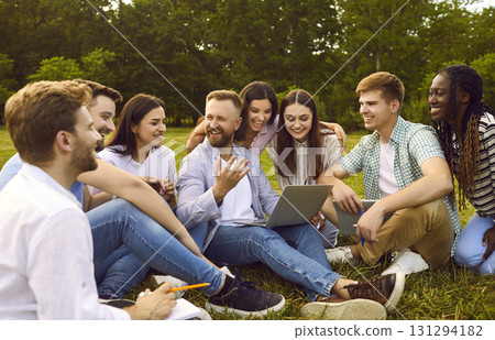 Group of happy diverse students are using laptop while studying outside together 131294182