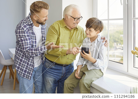 Happy family of three generation men, grandfather, father, son, cute child grandson with smartphone Happy family of three generation men, grandfather, father, son, cute child grandson with smartphone 131294186
