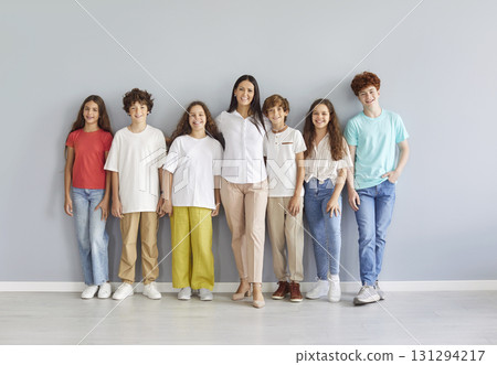 Portrait Of Happy Teacher And Group Of Students Standing On Grey Background Portrait Of Happy Teacher And Group Of Students Standing On Grey Background 131294217