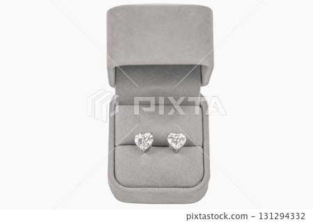 A pair of heart shaped diamond earrings are displayed in a gray box A pair of heart shaped diamond earrings are displayed in a gray box 131294332