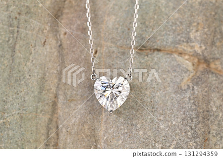 A heart shaped pendant with a diamond in the center A heart shaped pendant with a diamond in the center 131294359