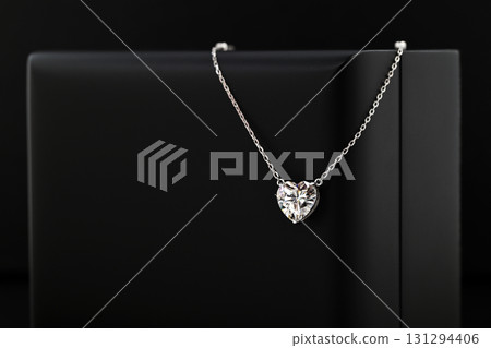 A necklace with a heart pendant is on a black record 131294406