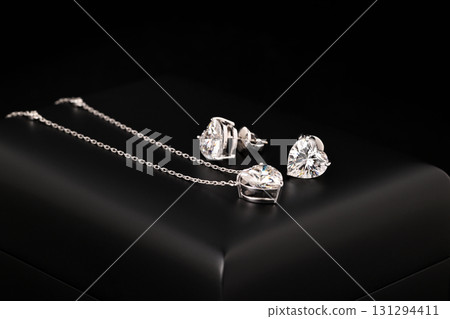 A heart shaped pendant with a chain is displayed in a black box A heart shaped pendant with a chain is displayed in a black box 131294411