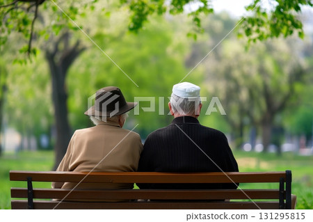 Elderly couple sitting quietly outdoors during Yom Kippur, holding hands in emotional connection 131295815