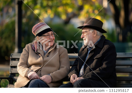 Elderly Jewish Couple Sitting Outdoors Holding Hands in Quiet Connection on Yom Kippur with Soft Green Background 131295817
