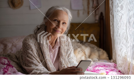 Senior woman shares advice from bed with cat, warm light, and handwritten notes. Ideal for personal vlog or senior lifestyle themes. 131296093
