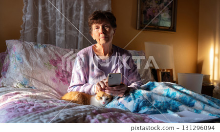 Grandma recording vertical advice video from bedroom with cat and soft light, cozy interior for real-life senior storytelling 131296094