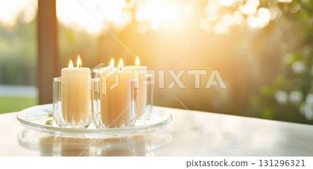 Crystal Glass Candle Plate with Dripping Wax and Burning Pastel Taper Candles in Elegant Interior 131296321