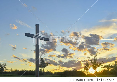 A great Christian cross in the landscape. A Christian cross highlighted by the sunset. The concept of religion and Christianity. 131296727