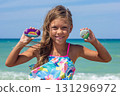 Happy Child Displaying Colorfully Painted Stones at the Beach 131296972