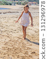 Girl Jumping on Hopscotch Drawn in the Sand 131296978