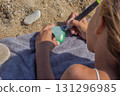 Kid coloring a smooth beach pebble using bright markers 131296985