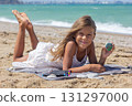 Smiling Child Showing Painted Stone on Beach 131297000