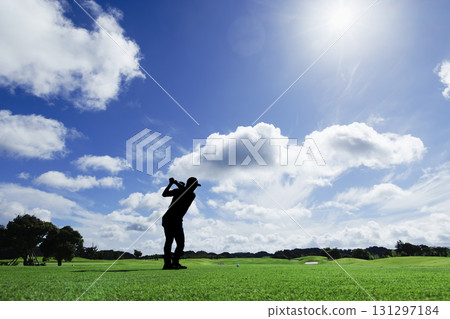 A person taking a shot on a tee ground surrounded by beautiful fresh greenery A person taking a shot on a tee ground surrounded by beautiful fresh greenery 131297184
