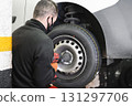 shot of an unrecognizable mechanic using an electric impact wrench to remove a car wheel 131297706