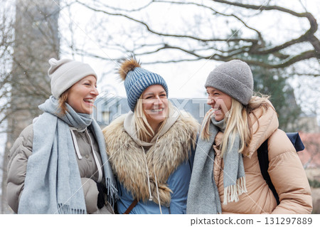 Three cheerful young adult women friend walk Magdeburg street old european uk german town city street enjoy having fun laughing cold winter day together. Female persons friendship celebration weekend Three cheerful young adult women friend walk Magdeburg street old european uk german town city street enjoy having fun laughing cold winter day together. Female persons friendship celebration weekend 131297889
