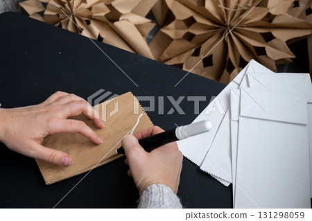 Process of preparing for Christmas star and New Year eve. 3D craft bag snowflakes DIY. Responsible ecological zero waste handmade decoration. Children hobby activity 131298059
