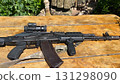 A Kalashnikov assault rifle is lying on the table  131298090