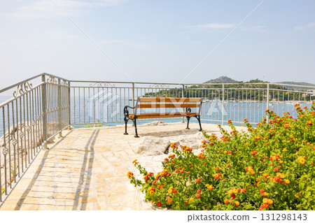 Bench and flower bed overlooking a small cove on the Adriatic Sea in Croatia, Europe 131298143