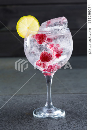 Gin tonic cocktail with raspberry lima slice and ice 131299084