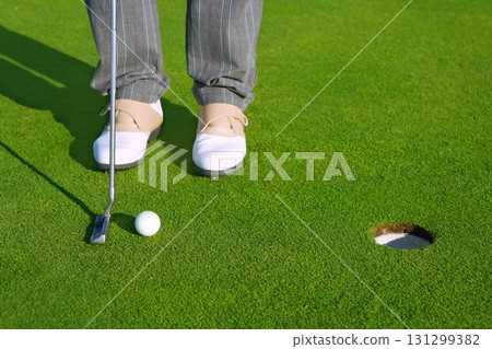 Golf green hole course man putting short ball 131299382