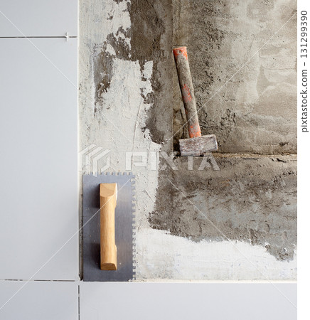 construction tools notched trowel and hammer 131299390