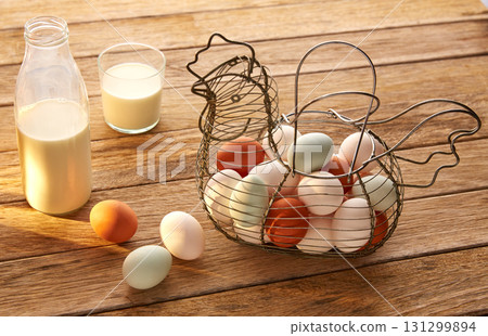Eggs and milk in a vintage hen shape basket on wood 131299894