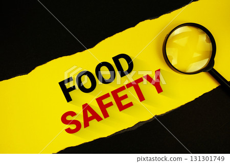 Food Safety text on yellow with black paper torn ripped and magnifying glass Food Safety text on yellow with black paper torn ripped and magnifying glass 131301749