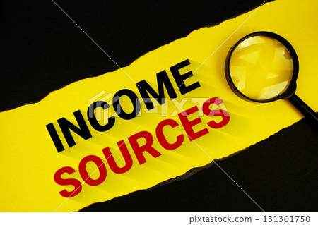 Income Sources text on yellow with black paper torn ripped and magnifying glass 131301750